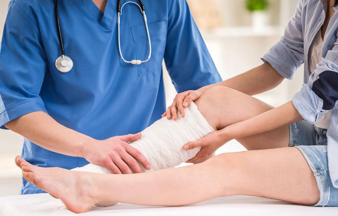 Urgent Care Physician caring for patient with injured leg